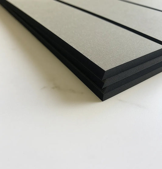 Stack of black textured boards on a light background