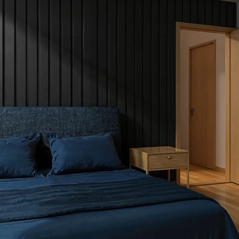 Dark-themed bedroom with a bed and nightstand, black slat wall panelling as a feature behind the bed.