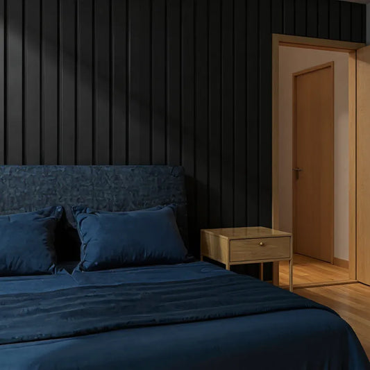 Dark-themed bedroom with a bed and nightstand, black slat wall panelling as a feature behind the bed.
