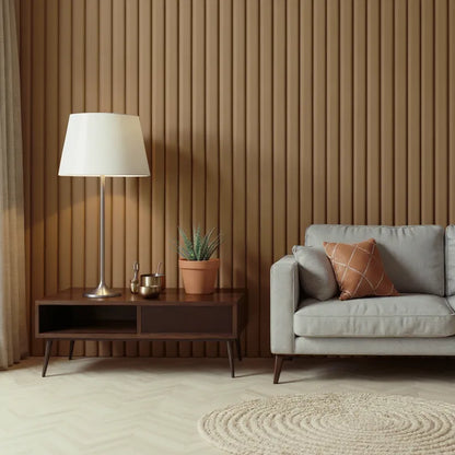 Modern minimalist living room with mid-century furniture, featuring a light gray sofa, brown accent pillow, wooden slat wall, floor lamp, indoor plant, and circular beige rug on herringbone flooring.