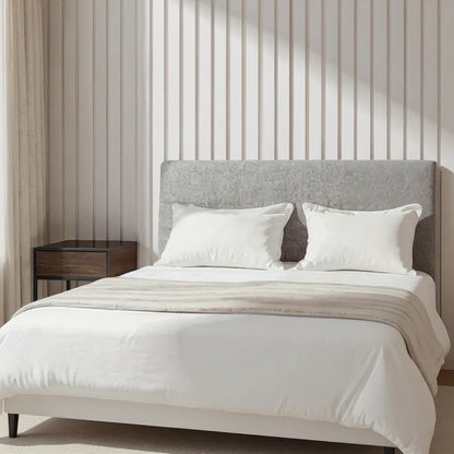 Bedroom with a bed featuring white bedding and a gray headboard and slat wall panels in the background.