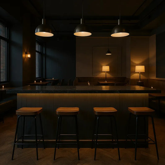 Dark interior of a bar with wooden stools and dim lighting with butt and bead style panelling on the barfront